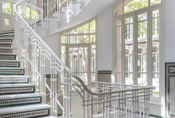 Fotografía de las escaleras de comunicación interior con decoración de azulejos.