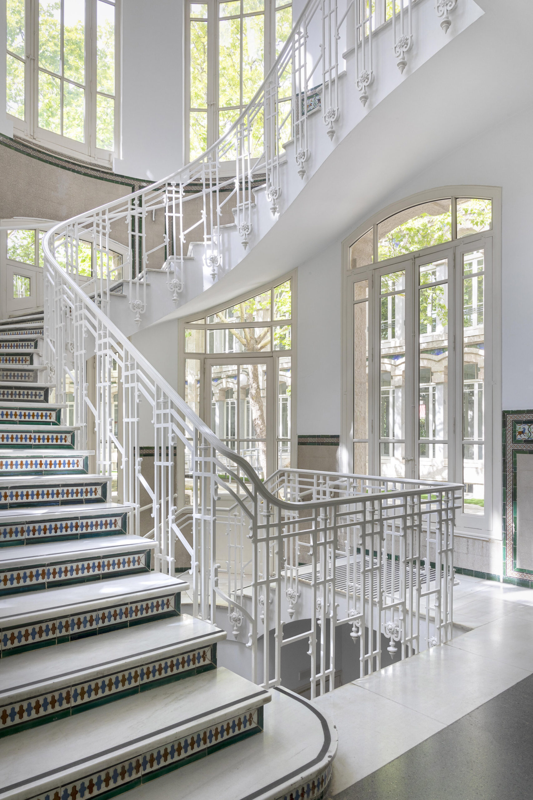 Fotografía de las escaleras de comunicación interior con decoración de azulejos.
