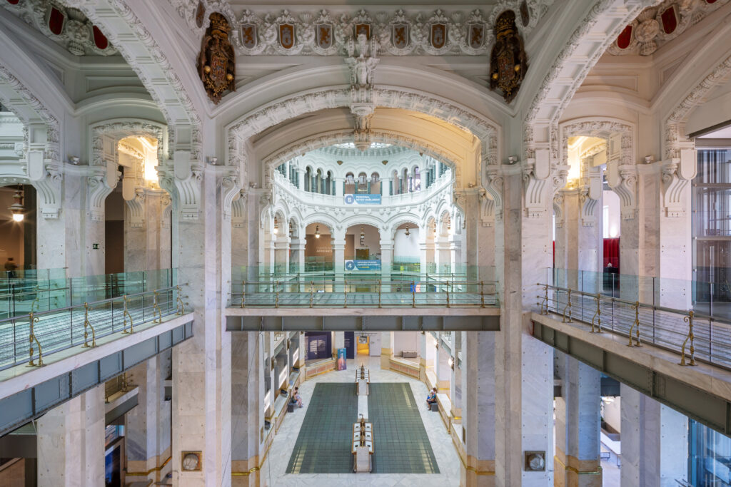 Vestíbulo interior de planta cruciforme y tres niveles de arquerías. Fotografía del vestíbulo interior de planta cruciforme y tres niveles de arquerías.